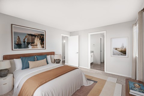 A bedroom with a large bed and a painting on the wall.