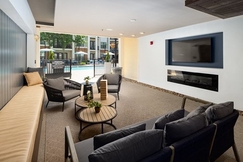 a living room with couches and a television in front of a pool