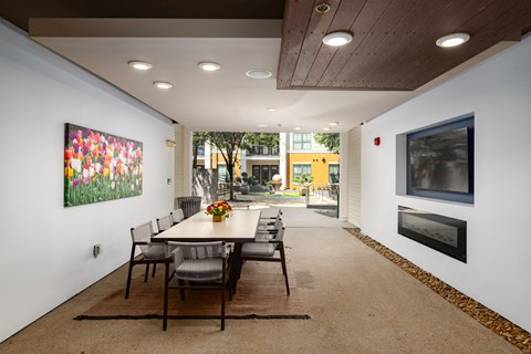 a long dining room with a long table and chairs and a large colorful painting on the wall