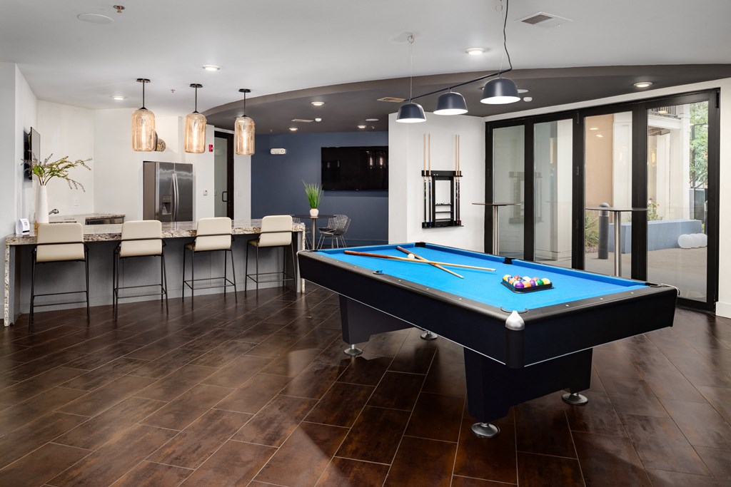 a games room with a pool table and a bar with stools