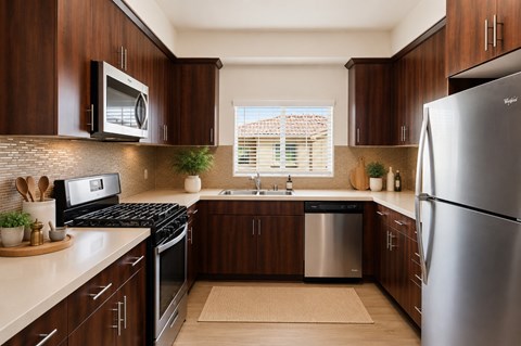 A modern kitchen with dark wood cabinets and stainless steel appliances.