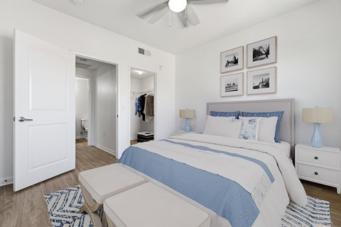 A bedroom with a bed, nightstand, and a ceiling fan.