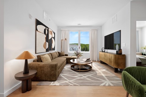 A living room with a brown couch, a green armchair, a coffee table, and a painting on the wall.