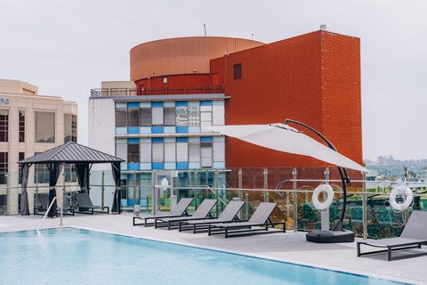 A pool area with a red building in the background.