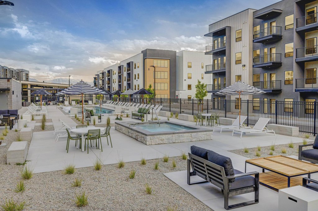 A modern outdoor seating area with a pool and lounge chairs.