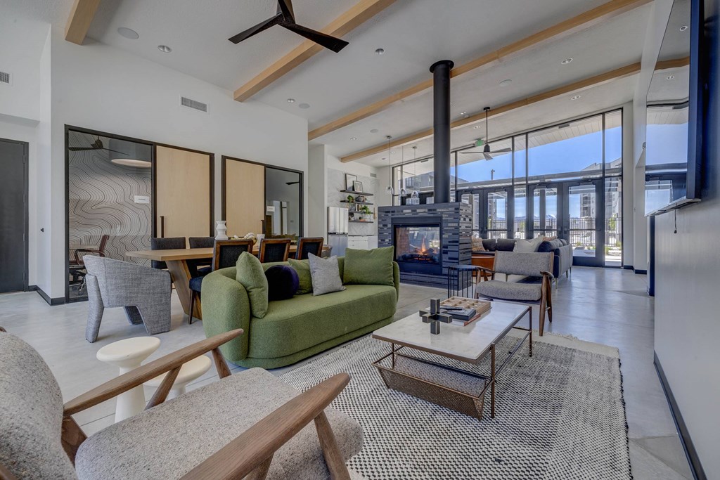 A modern living room with a green couch and a fireplace.