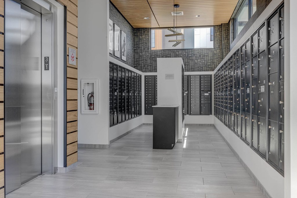 A hallway with a black trash can in the middle.