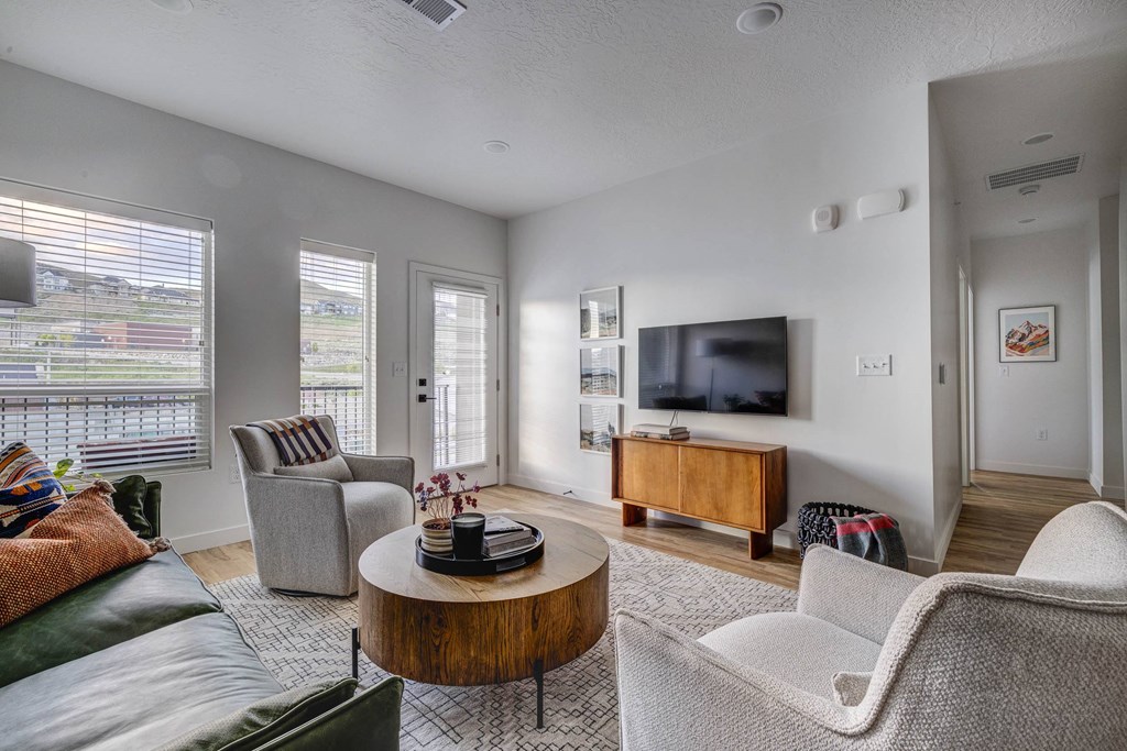 a living room with a couch and chairs and a tv