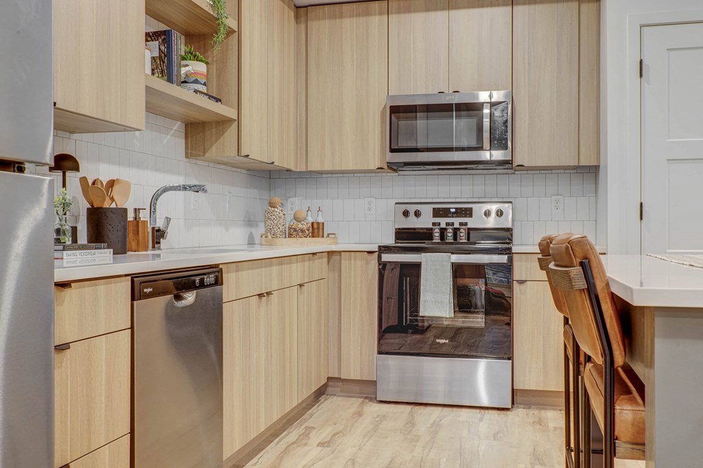 a kitchen with wooden cabinets and stainless steel appliances