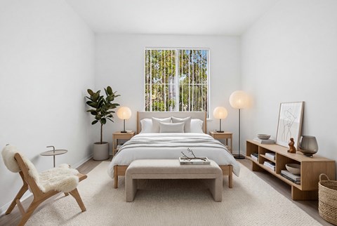 A bedroom with a large bed, a chair, and a plant.