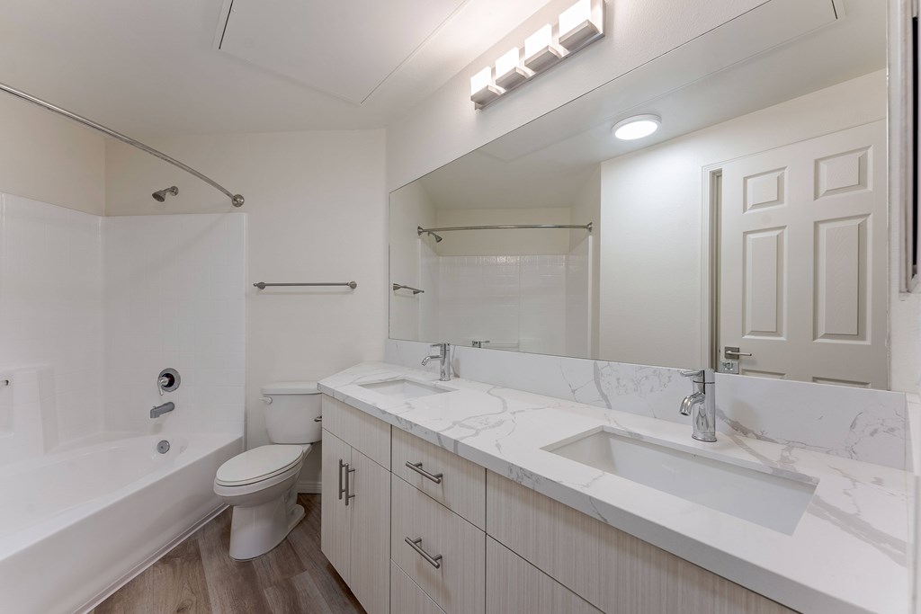 A white bathroom with a toilet, sink, and bathtub.