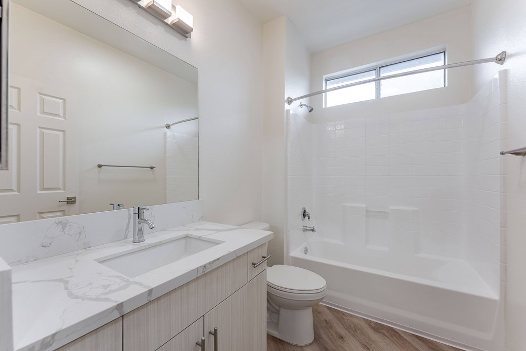 A white bathroom with a toilet, sink, and bathtub.