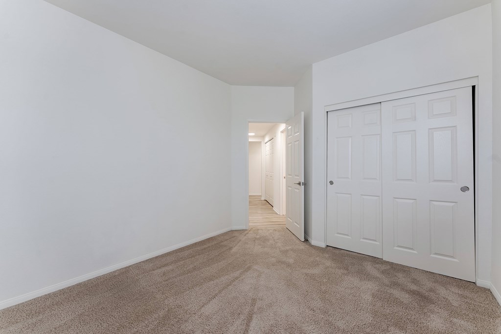 A room with a carpeted floor and a white door.