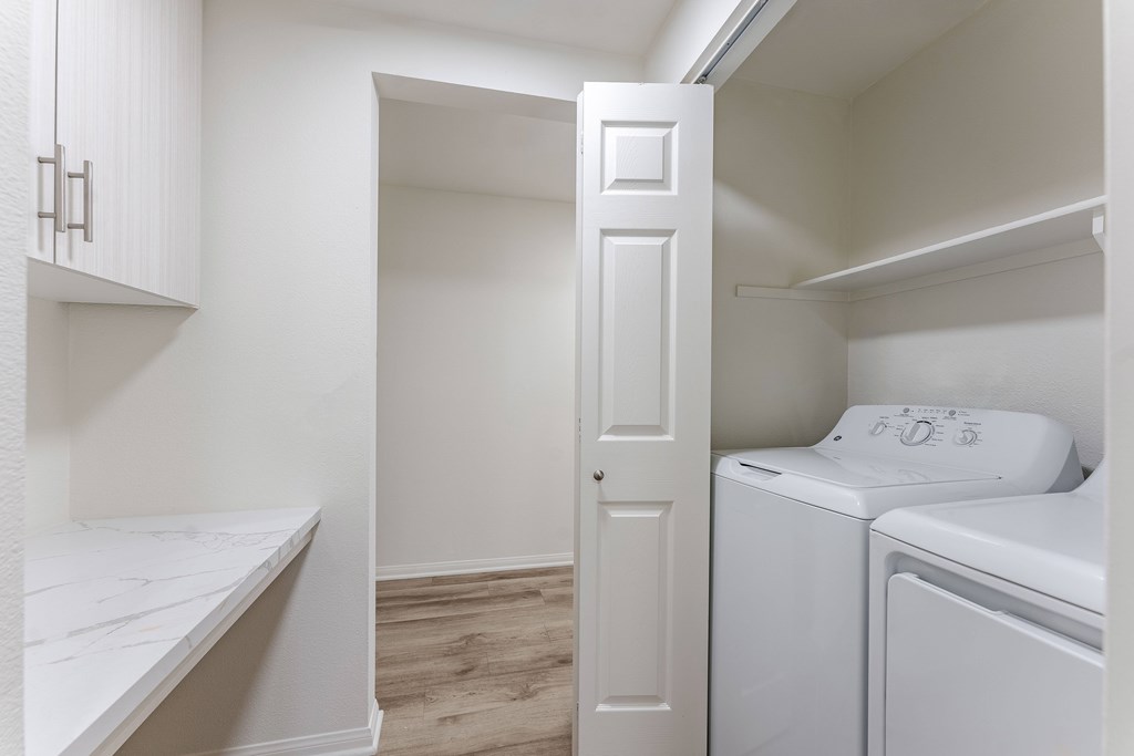 A white door is open to a laundry room.