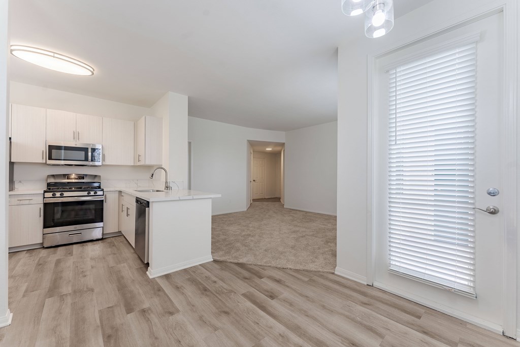 A kitchen with white cabinets and a microwave above the stove.