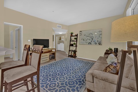 A living room with a blue patterned carpet and a brown couch.
