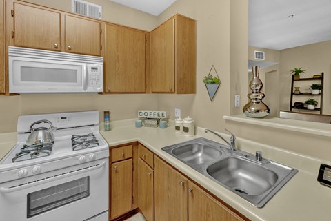 A kitchen with a white stove and wooden cabinets.