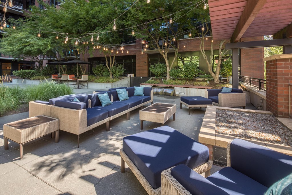 a patio with couches and chairs and a fire pit