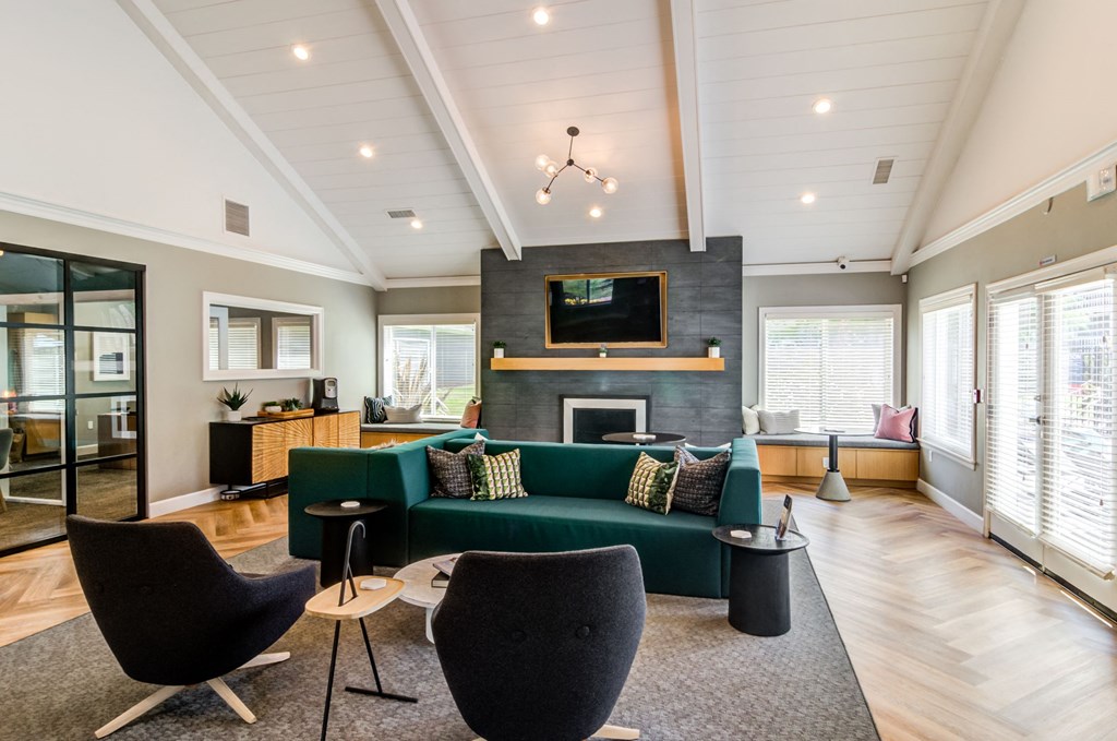 a spacious community room with couches and a TV mounted over a fireplace at The Arden Apartments, Gresham