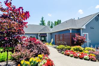 the front of the arden leasing office with a sidewalk and colorful flowers in front of it at The Arden Apartments, Gresham, 97080
