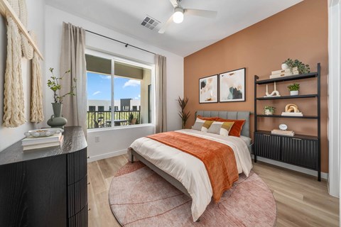 A bedroom with a large bed and a view of a balcony.