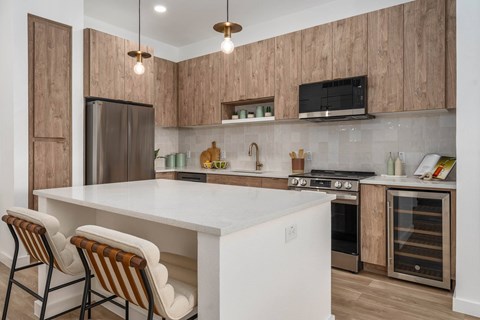 A kitchen with a white island and striped chairs.