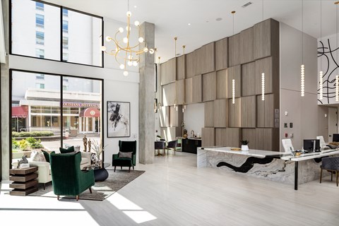 a living room with a desk and a large window