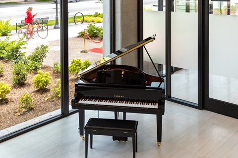 a piano sits in a room in front of a window