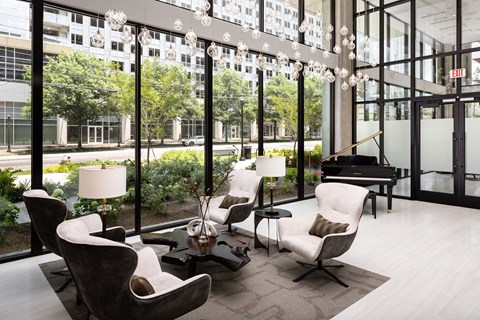 a living room with chairs and a piano