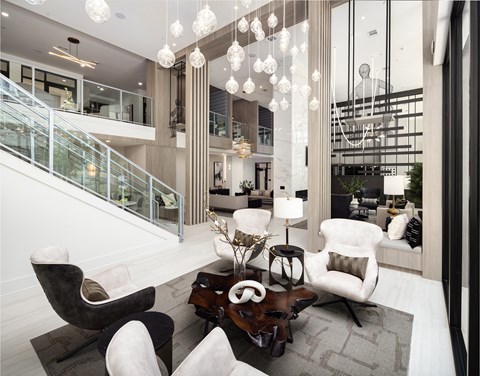 a living room with white furniture and large glass windows