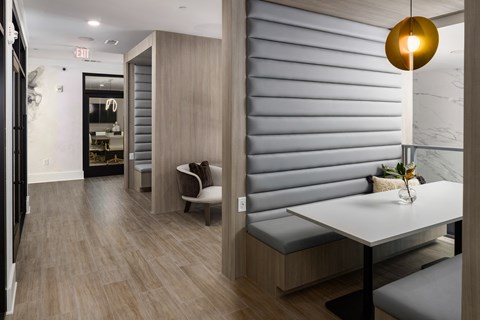 a dining room with a table and a chair and a hallway with a door