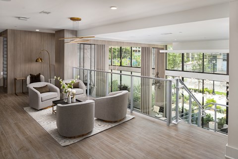 a living room with couches and chairs and a balcony