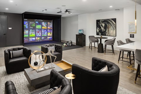 a living room with couches and a table with chairs and a projection screen in