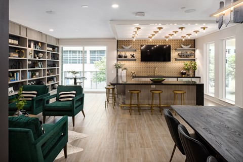 a living room with a table and chairs and a kitchen with a tv