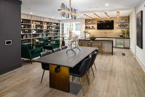 a dining room with a table and chairs and a cat in the center of it