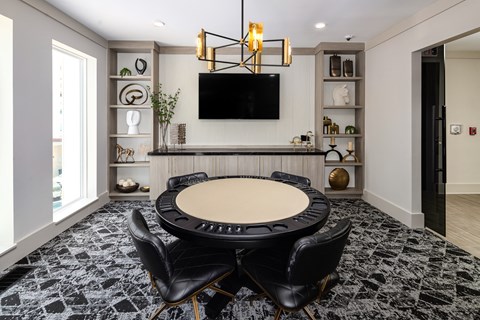 a conference room with a round table and chairs and a television