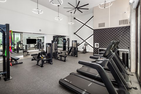 a gym with treadmills and other exercise equipment and a large window