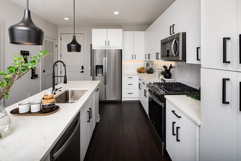 a kitchen with white cabinets and a stainless steel refrigerator