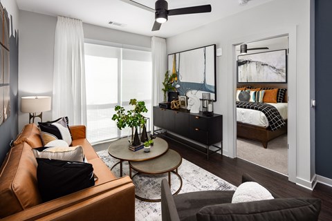 a living room with a couch and a table and a bedroom with a bed