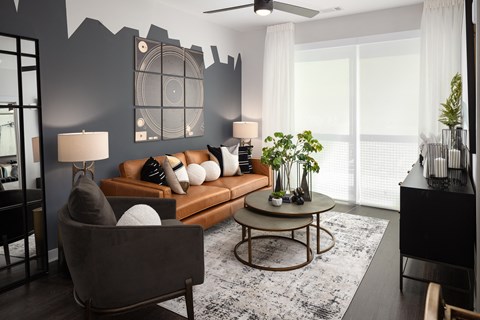 a living room with a brown couch and a large window