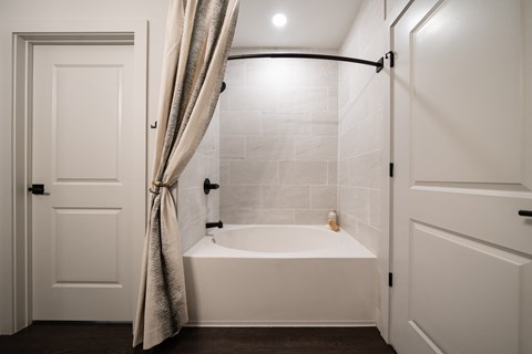a small bathroom with a tub and a curtain