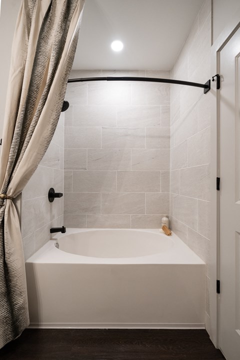 a small bathroom with a white tub and a shower curtain