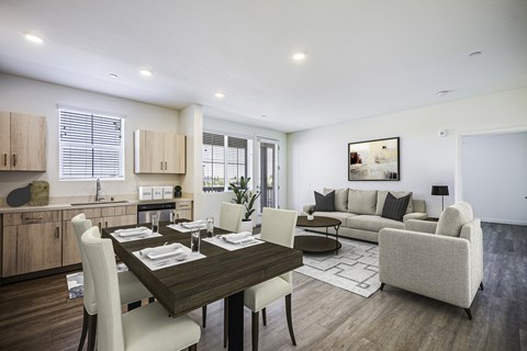 A modern dining room with a wooden table and white chairs.