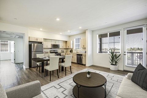 A modern kitchen with a dining table and chairs in the middle of the room.