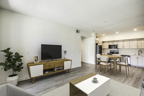 A modern living room with a wooden entertainment center and a grey sofa.