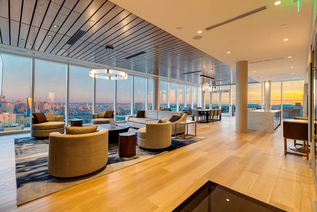 a lounge area with couches and chairs and a view of the city