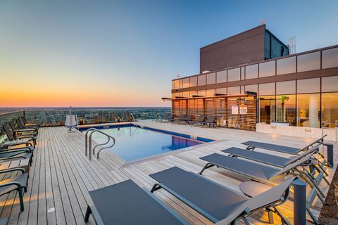 the pool on the rooftop of a building at sunset