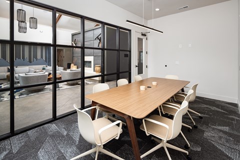 a conference room with a wooden table and white chairs