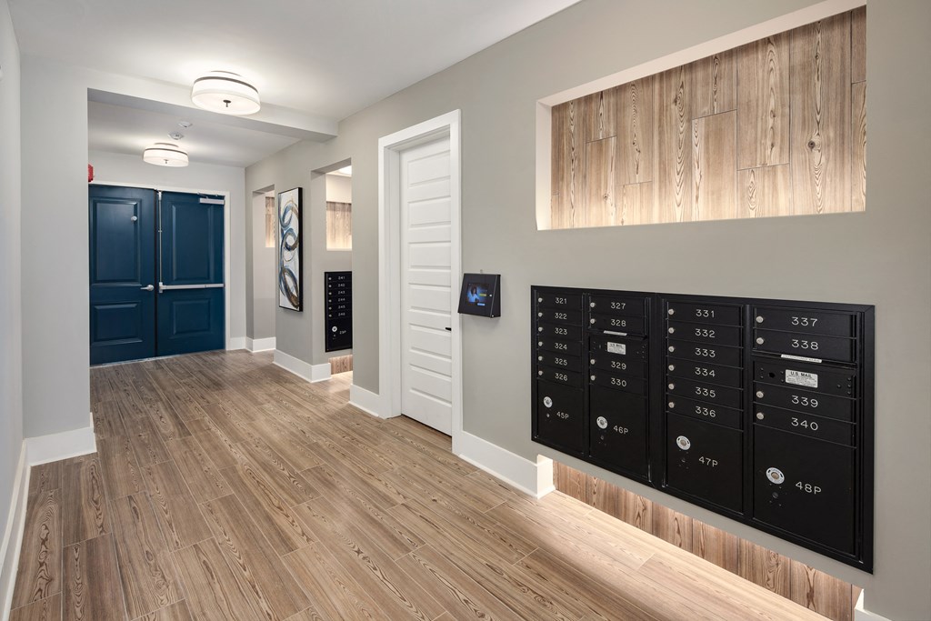 a view of a hallway with a large locker wall and a door to a closet