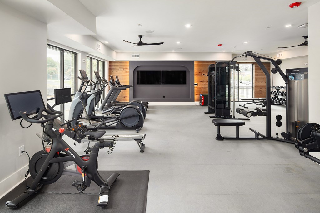 a gym with exercise equipment and a tv in the back
